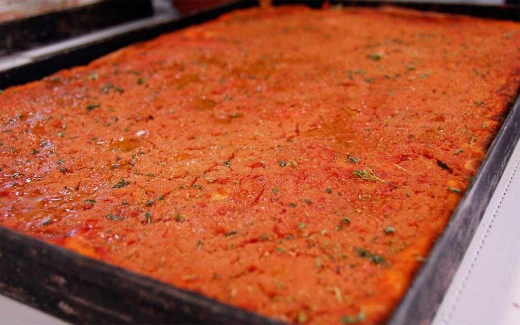 pan of sicilian pizza covered in red sauce