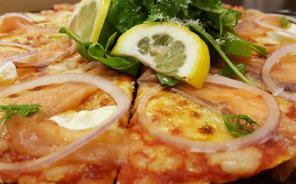 fresh lake fish on homemade pizza with lemon