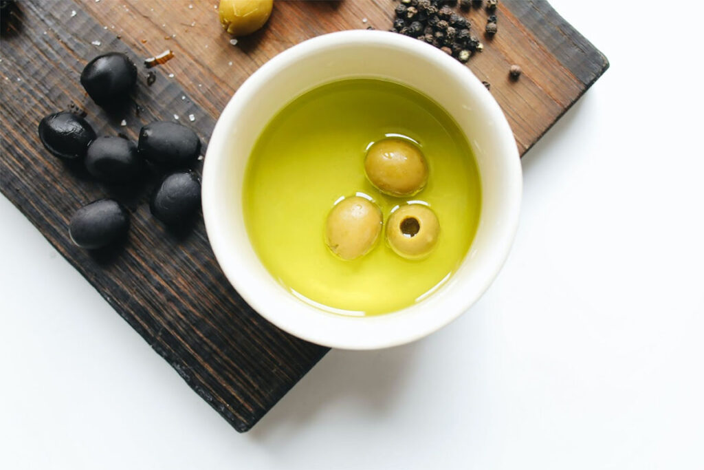 black and green olives in a bowl of olive oil