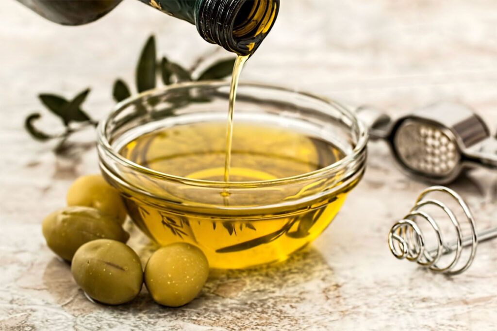pouring olive oil into a glass bowl