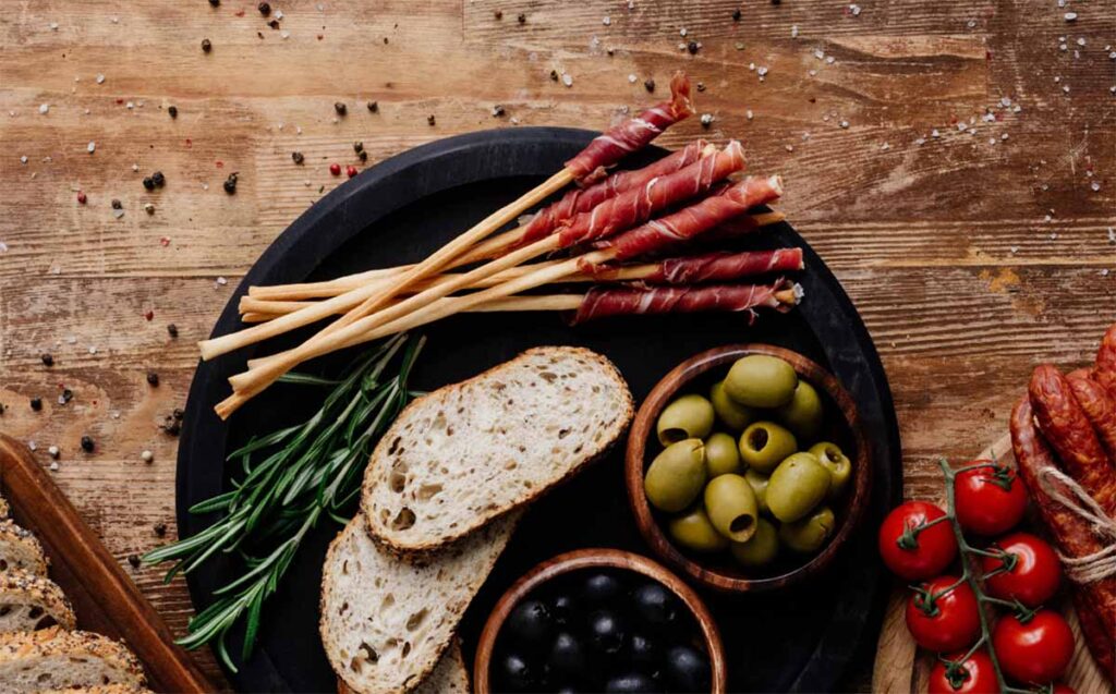 breadsticks meat olives all together on an appetizer plate