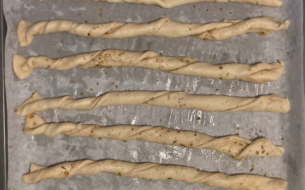 twisted dough spiced up on a baking sheet ready to be baked
